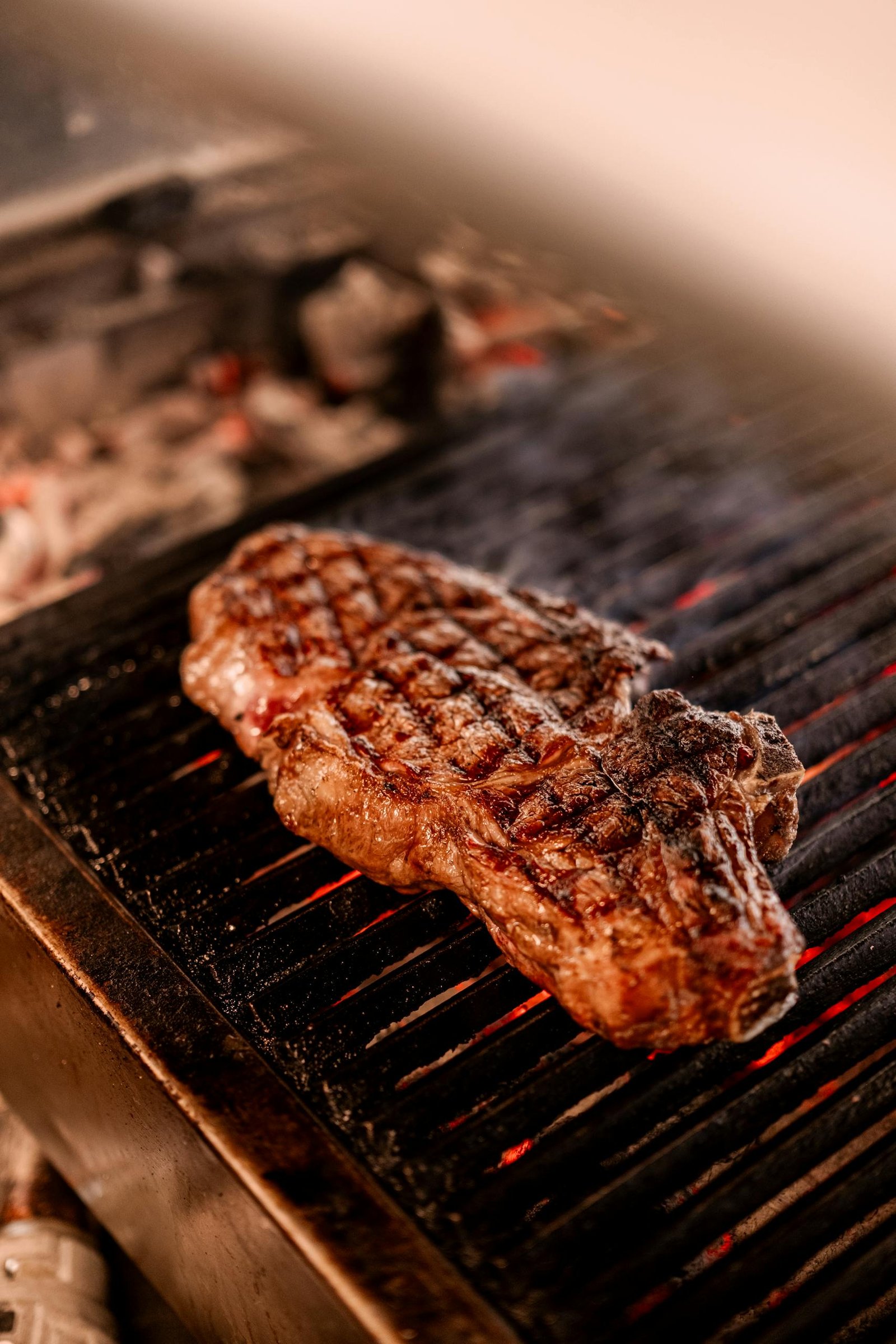 Juicy grilled steak sizzling on a barbecue grill, perfect for culinary or food themes.