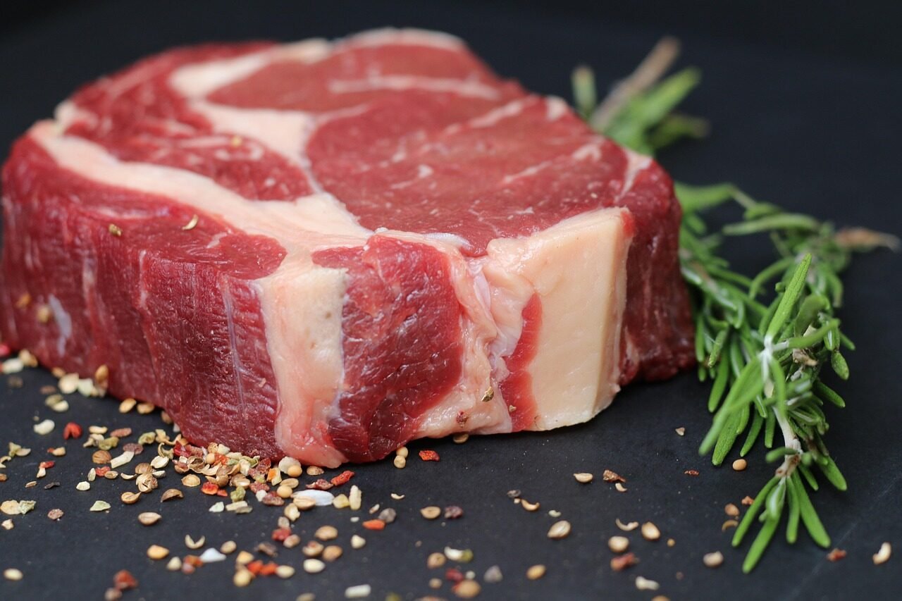 Raw ribeye seasoned on a cutting board to avoid steak grilling mistakes