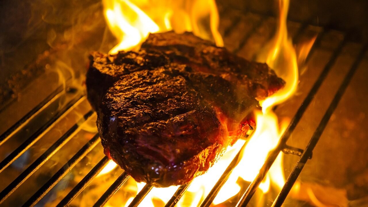 Raw ribeye seasoned on a cutting board to avoid steak grilling mistakes